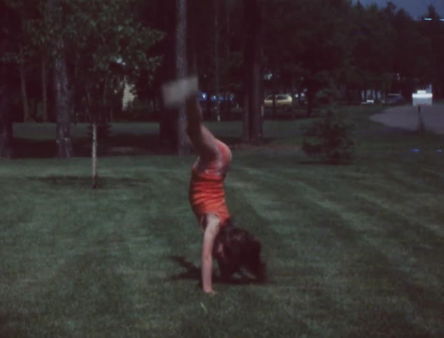 Kids do cartwheels on a grassy lawn