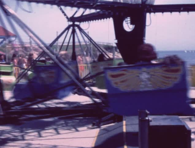 An old film of people riding a ride at a fair