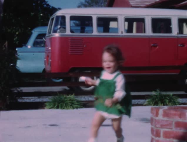 Toddler girl running and laughing in yard at home