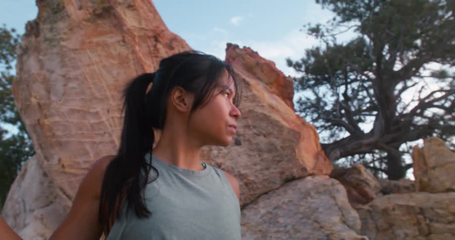 Woman walks around boulders on the mountain
