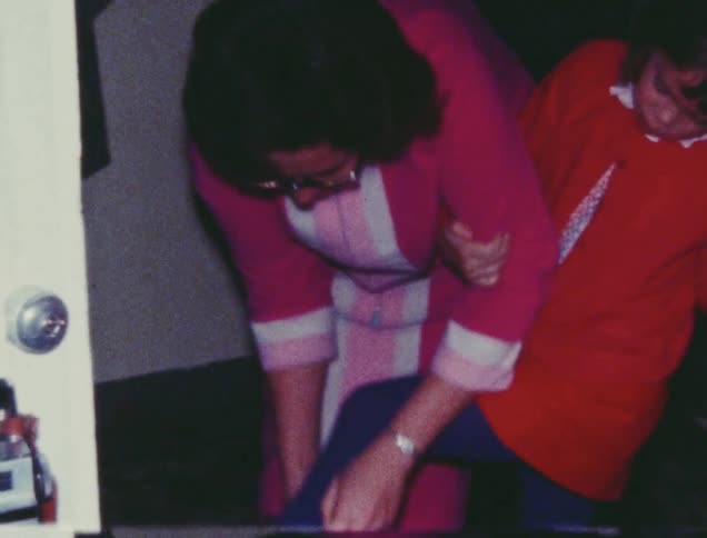 A woman is putting shoes on a girl