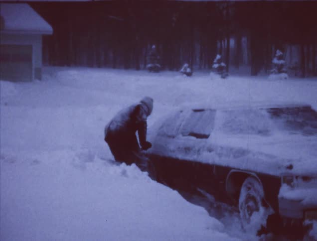 A man is digging his car out of the snow