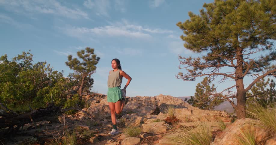 The woman stretches on the mountain