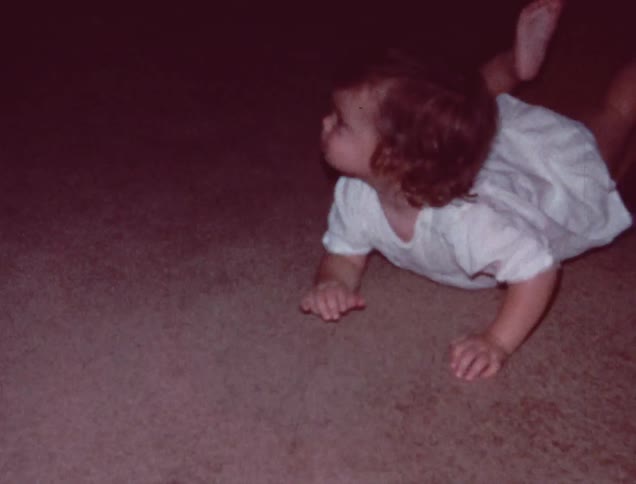 A baby is crawling over some furniture