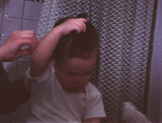 A woman combs a young child's hair