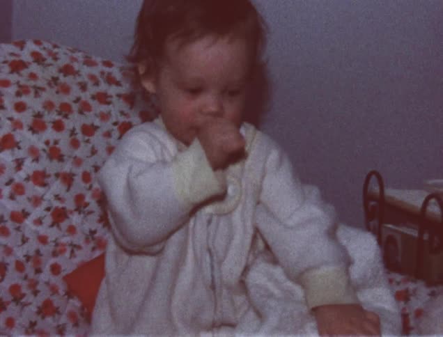 A child is playing with their thumb in their mouth