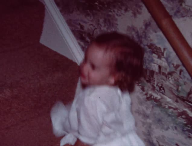 A toddler slides down stairs on her stomach