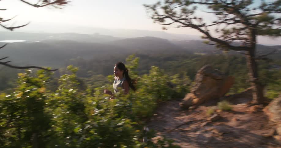 The woman is running fast on the mountain
