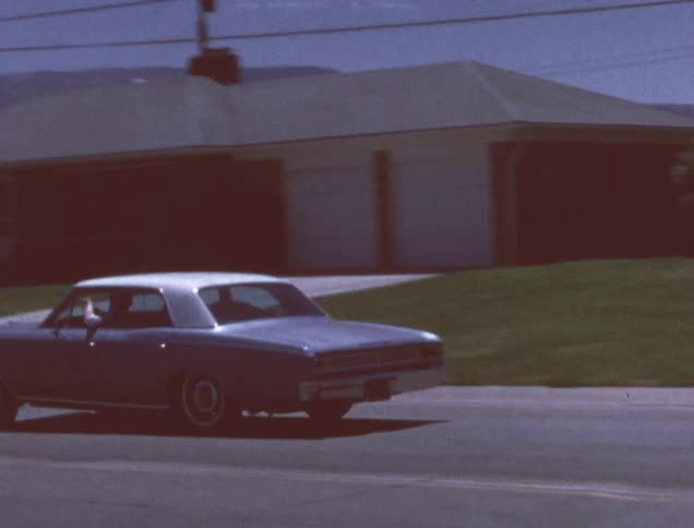 A man waves from the car window as he drives away