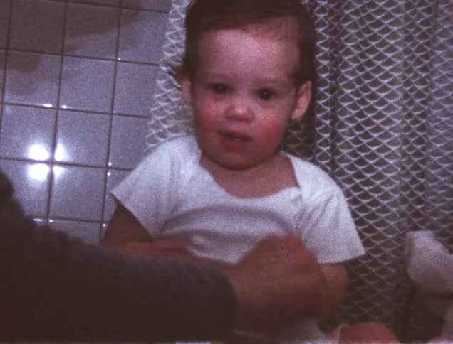 A person applies lotion to a baby