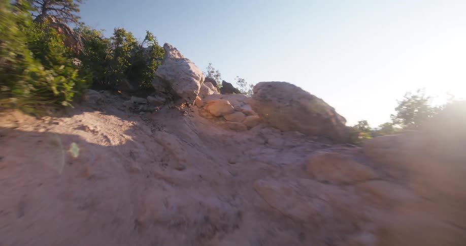 Person running up a rocky hill on a sunny day