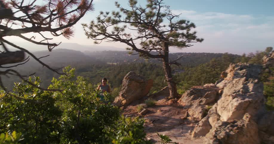 The woman runs fast uphill on the mountain trail