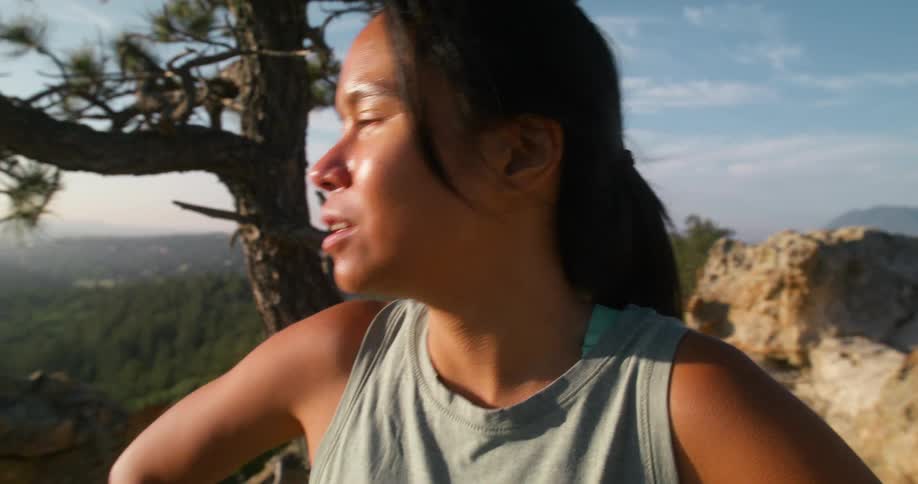 The woman breaths heavily on the mountain before running