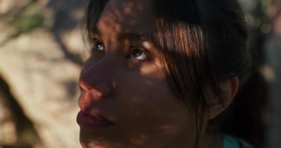 Portrait of a woman in an outdoor setting with sun reflection and shadow on her face