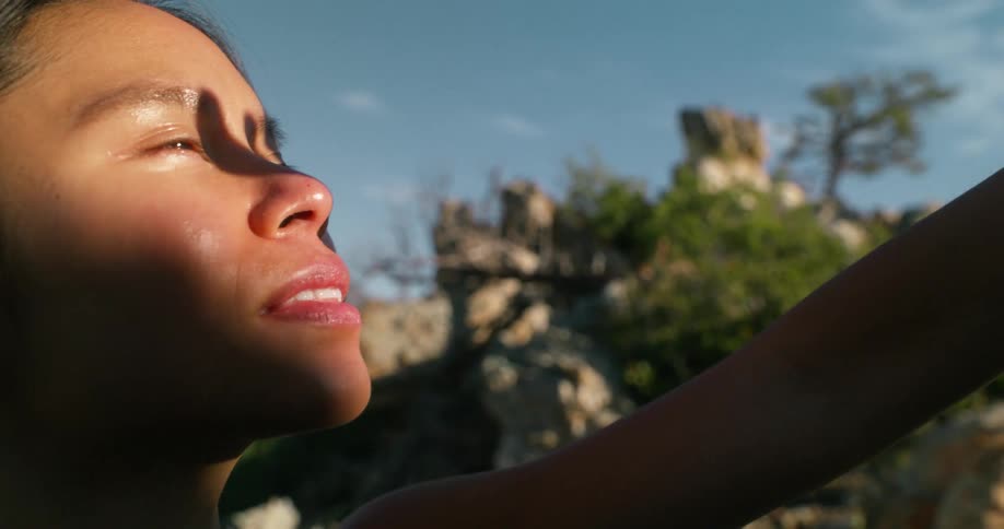 The woman covers her eyes from the sunlight