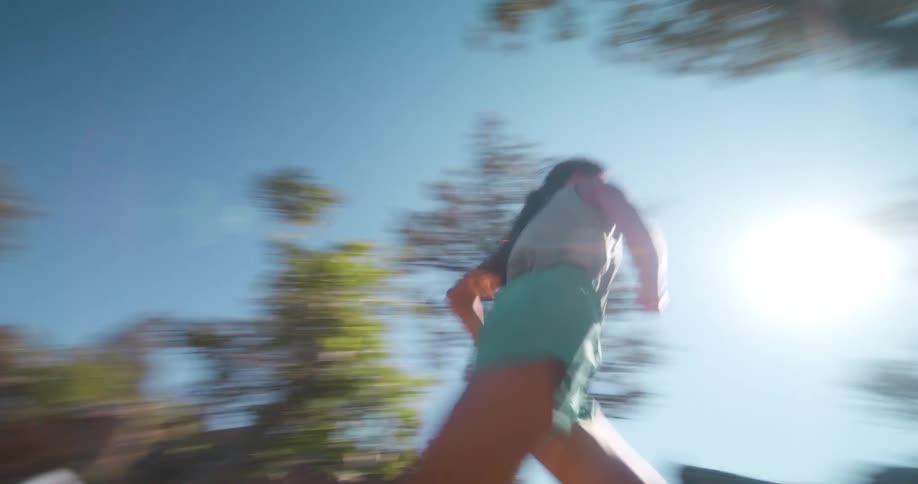 A woman runs through the woods at midday