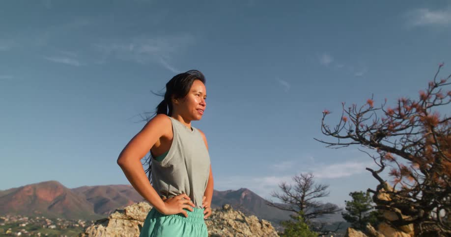 On a windy day a woman stands on the mountain top