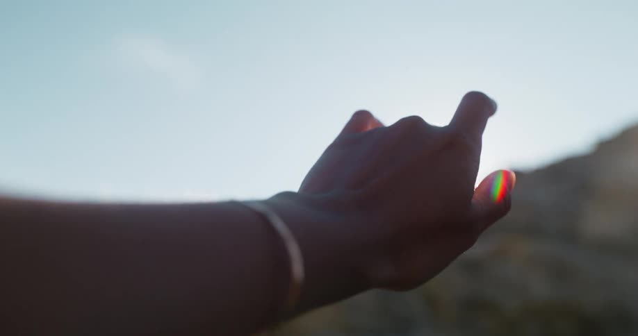 Persons hand against the sun