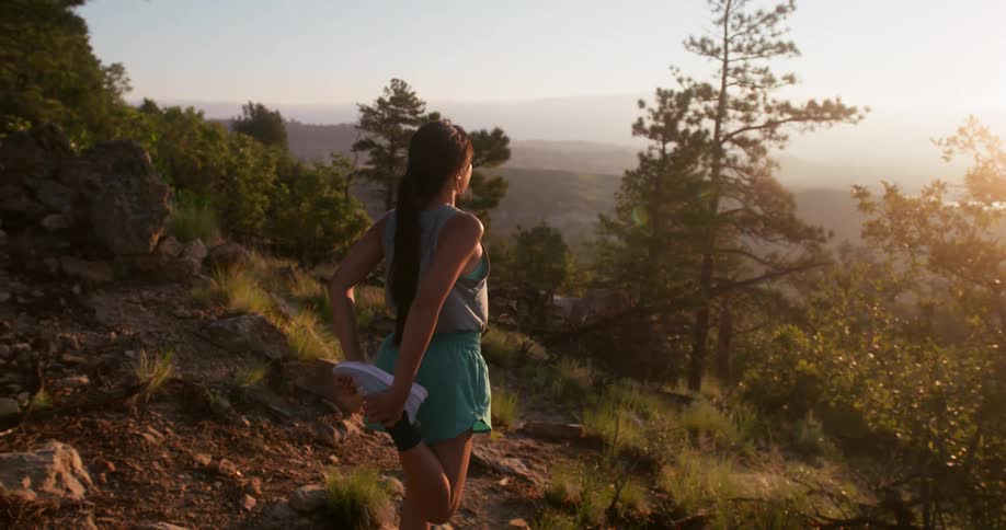 The woman watches the sunrise from the mountain top