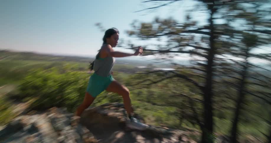 Woman in blue shorts running through the mountains during the day