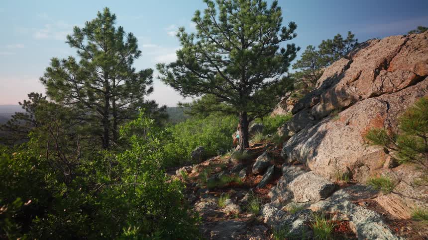 The woman turns the corner of the rocks on the mountain while running