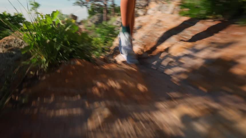 A woman runs on a rocky path at midday