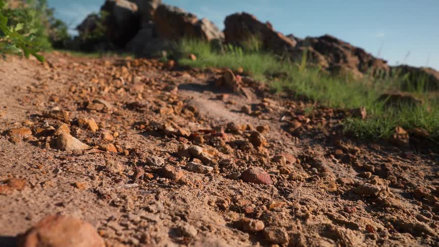 A person is jogging on rocky terrain during nice weather