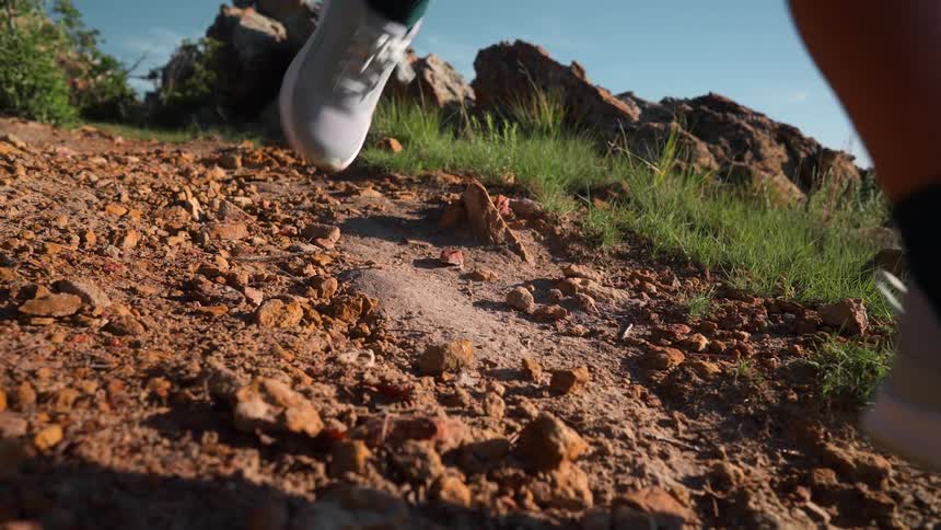 Person is jogging downhill on rock terrain