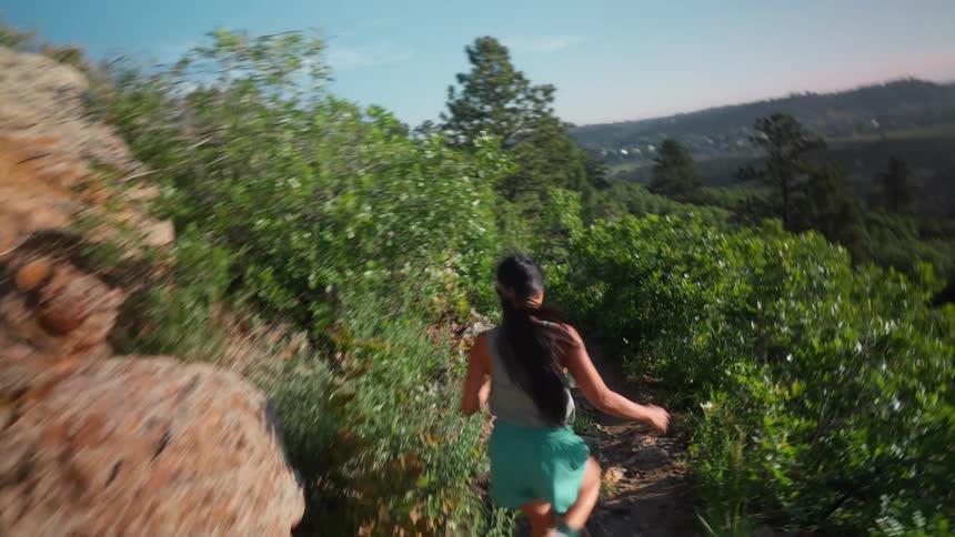 Woman in shorts running on a trail during the day