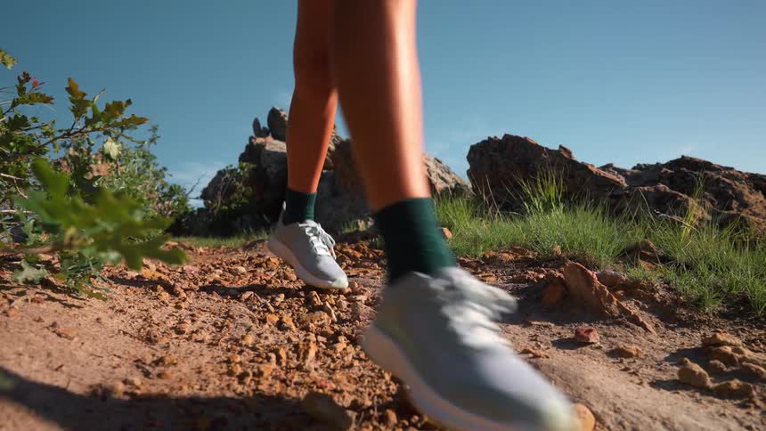 A female running down a rocky trail outdoors