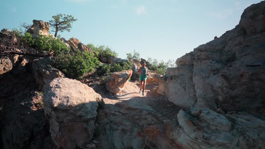Woman running intensely on a mountain trail