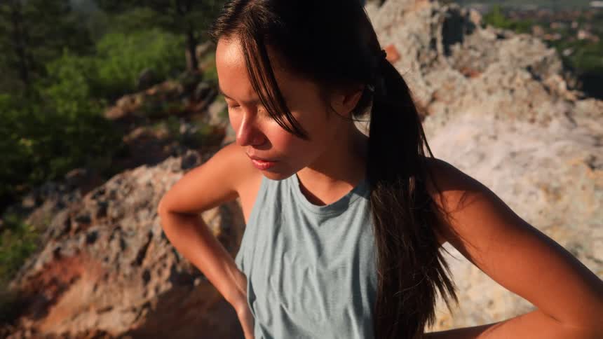 Woman on a mountain taking a deep breath