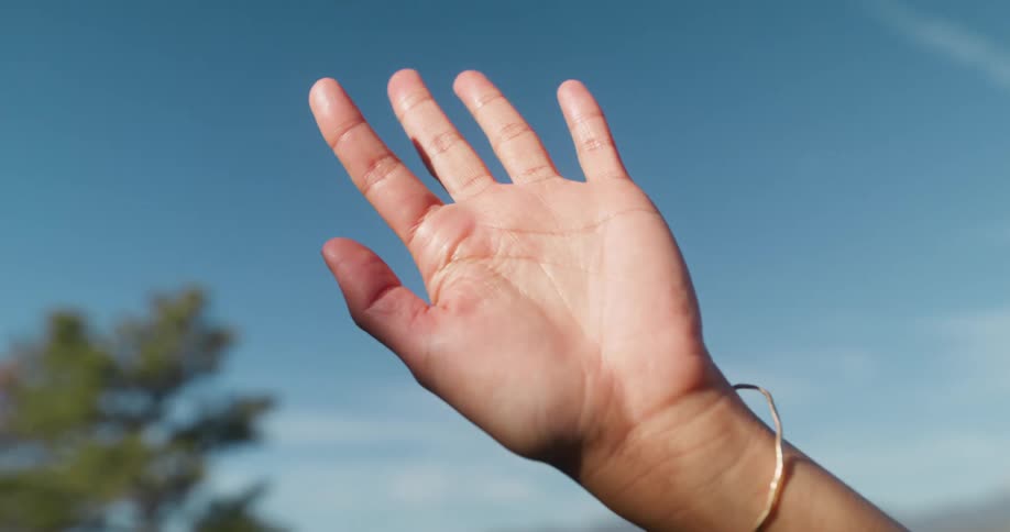 A woman waves her hand in the sky