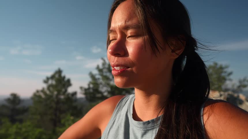 A woman is catching her breath on the mountain