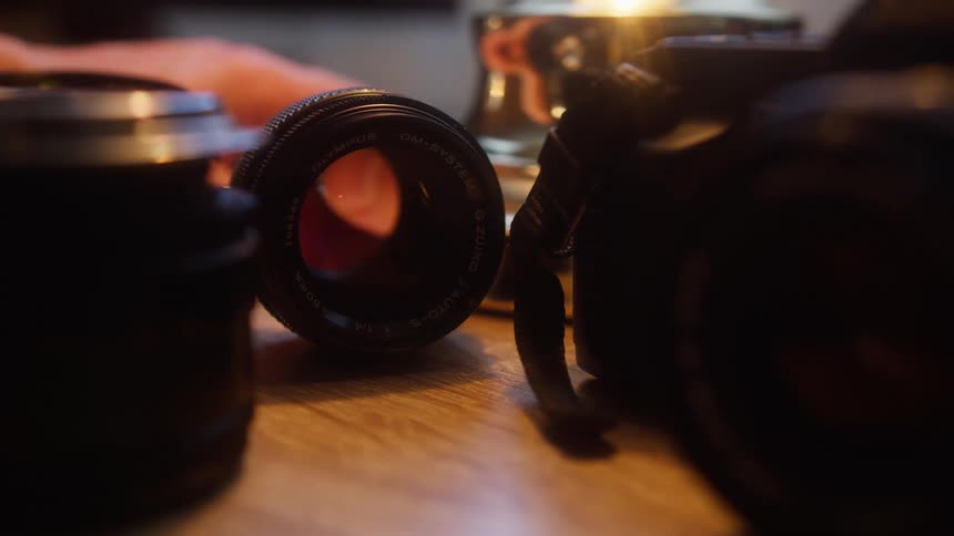 Camera and lenses on top of a wooden bench