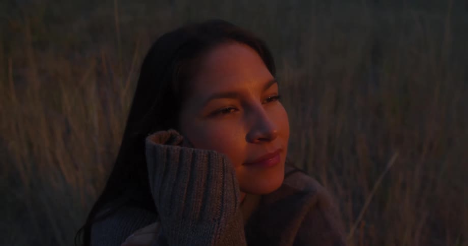 A woman sits in the grass during the night time