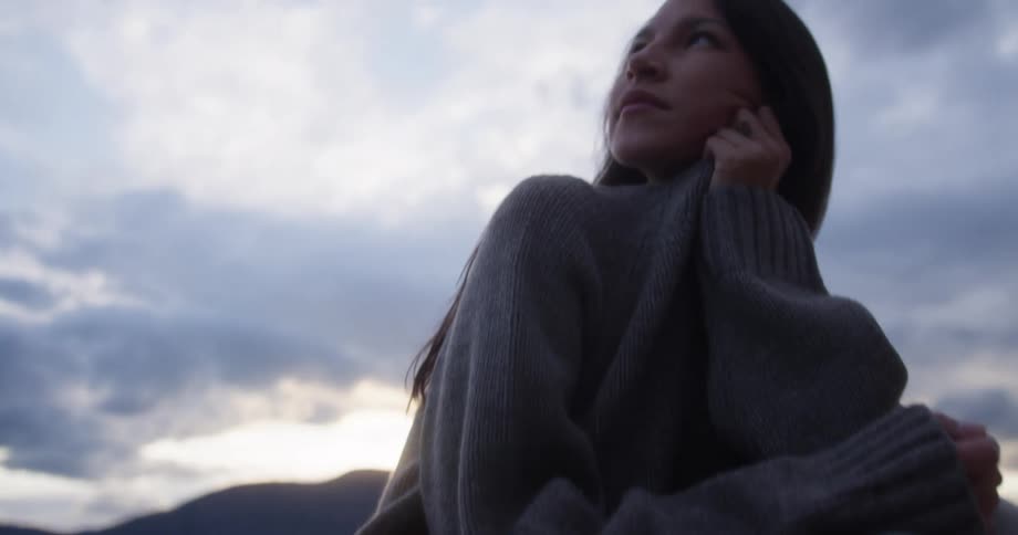 Woman sitting on a rock and looking in the distance
