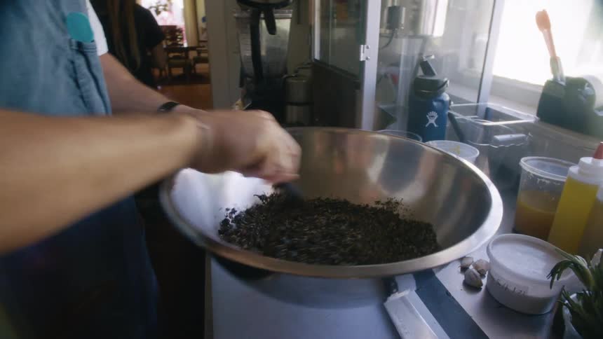 A chef is mixing food in the bowl