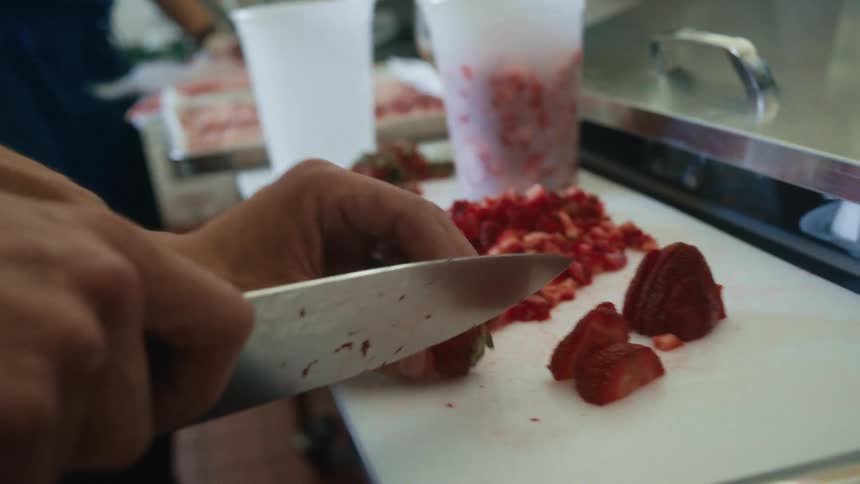 The chef is cutting strawberries