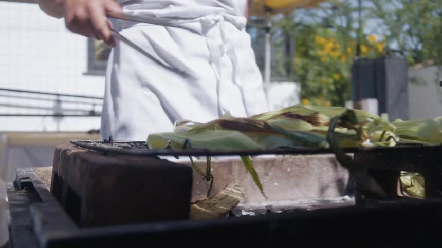 A man flips vegetables on the grill
