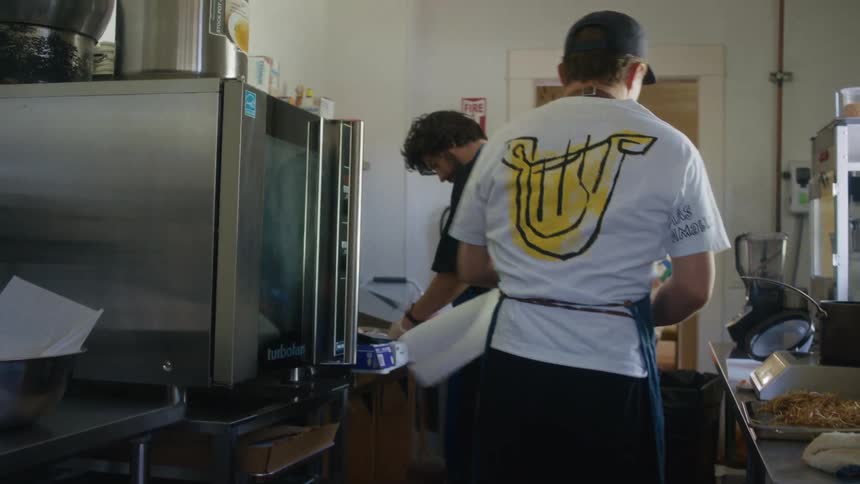 Two people prepare food in a kitchen