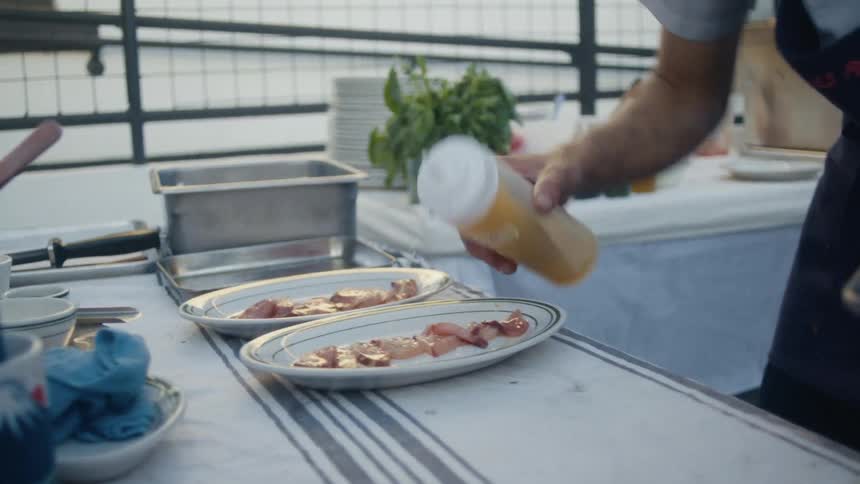 Sauce being placed on a plate on a table