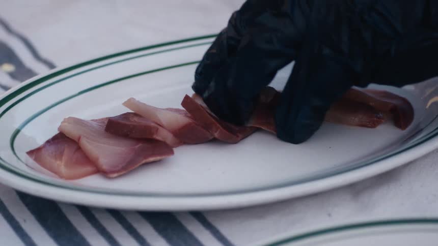 A cook is plating food outside