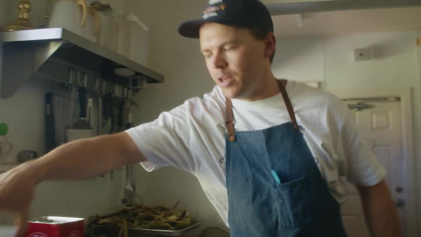 A server prepares and serves food in a busy restaurant kitchen
