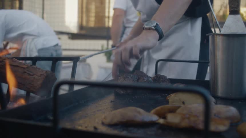 The chef is testing the meat on the barbecue
