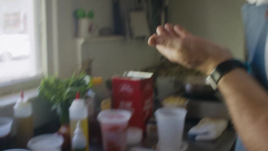 The man is tasting the food in the bowl