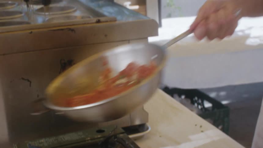 Person cooking stirring food in a pan