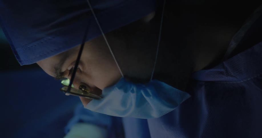 Side portrait of a female surgeon with glasses looking focused
