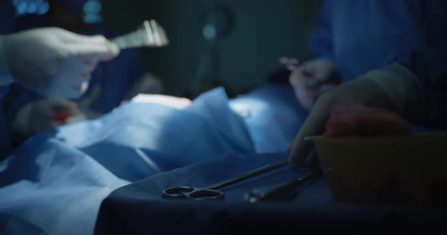 Medical team with a patient passing surgical tools between them