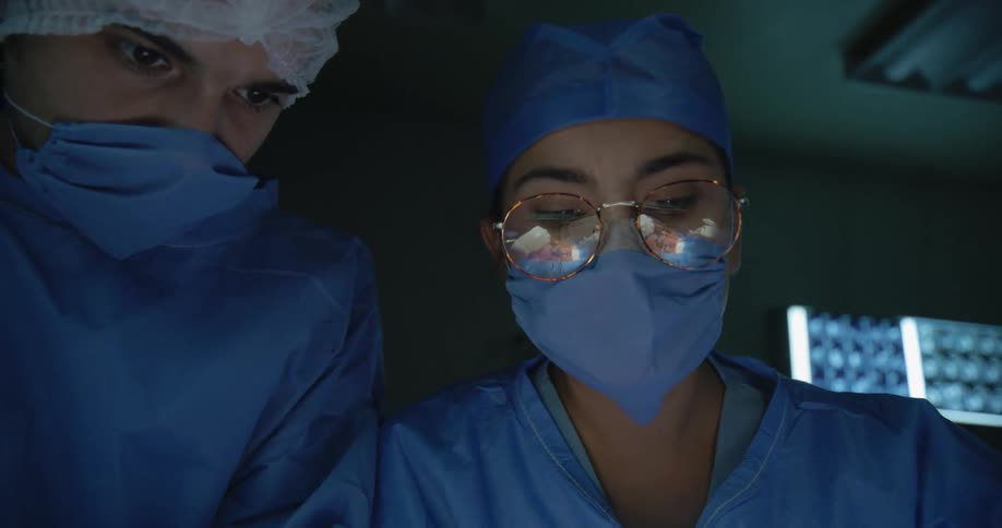 The surgeon talks to a colleague and nods